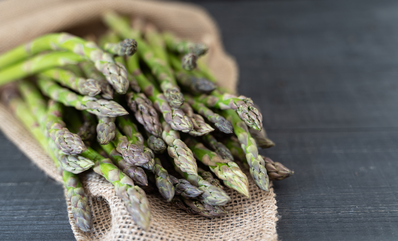 Raw green asparagus on burlap — Greens & Salads