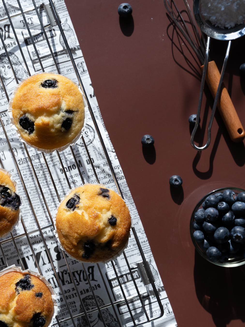 Blueberry muffins on newsprint — Bakery Notes