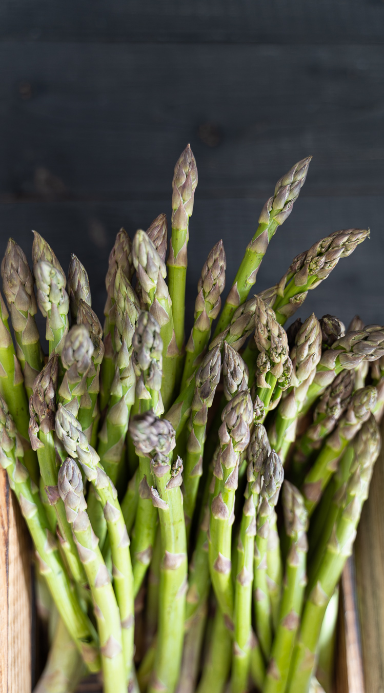 Raw asparagus tips vertical in crate — Greens & Salads