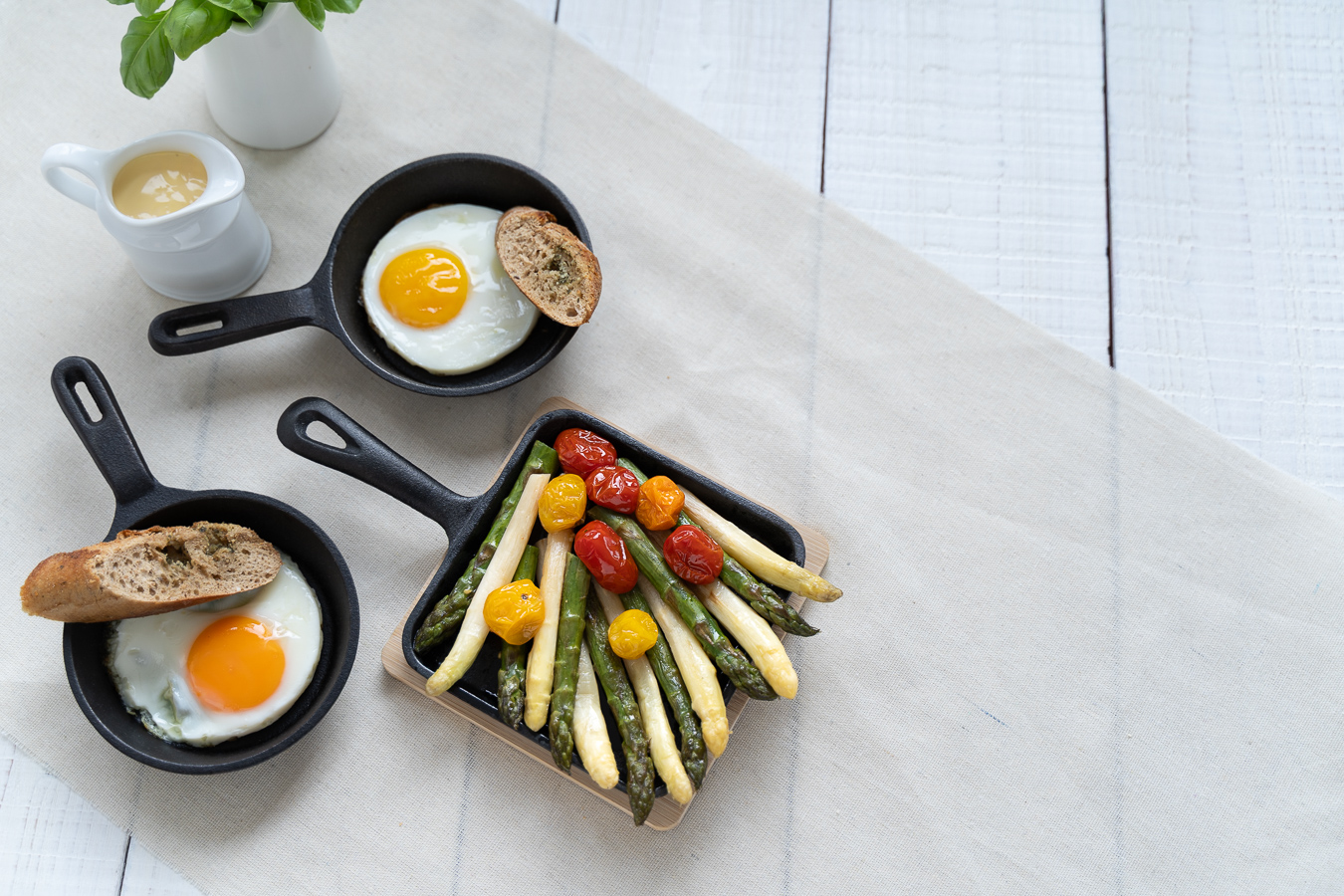 Two skillets with fried egg and asparagus overhead — Green Kitchen